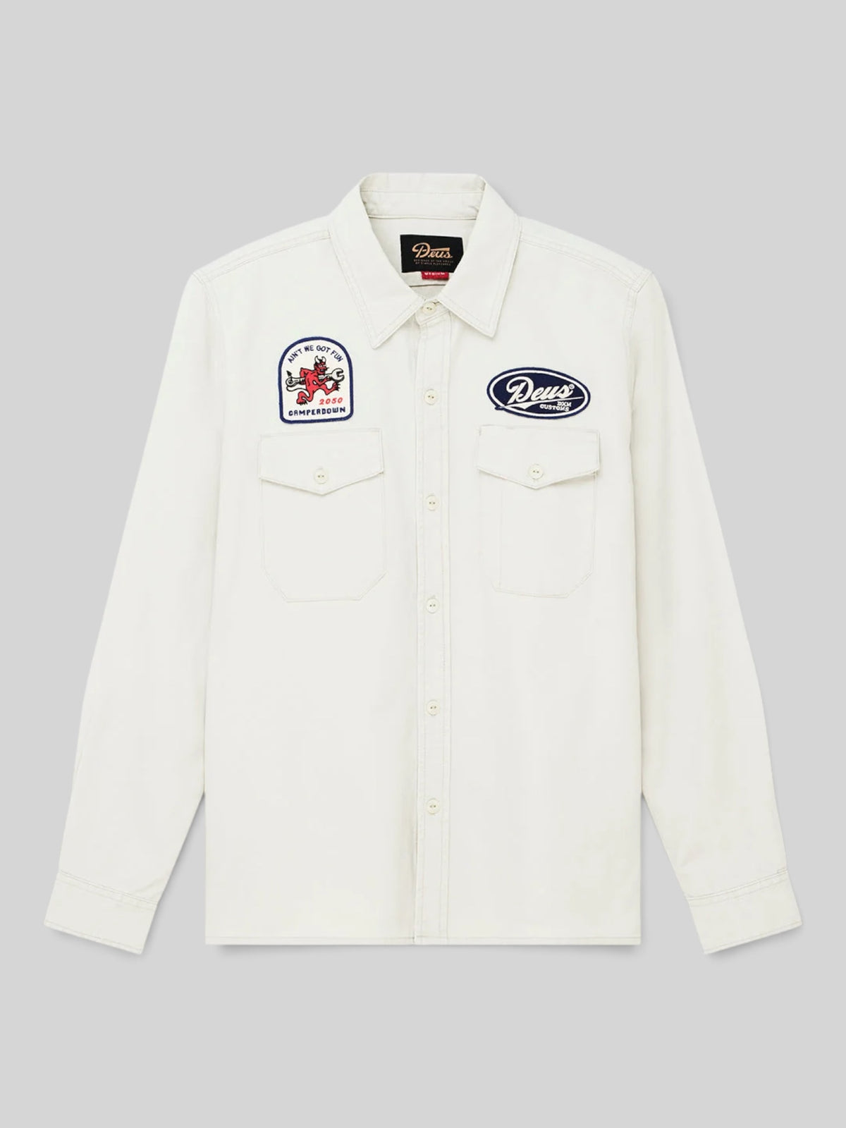 Baffle Haus Nomad shirt in dirty white cotton twill with embroidered patches, chest pockets, and button closure.
