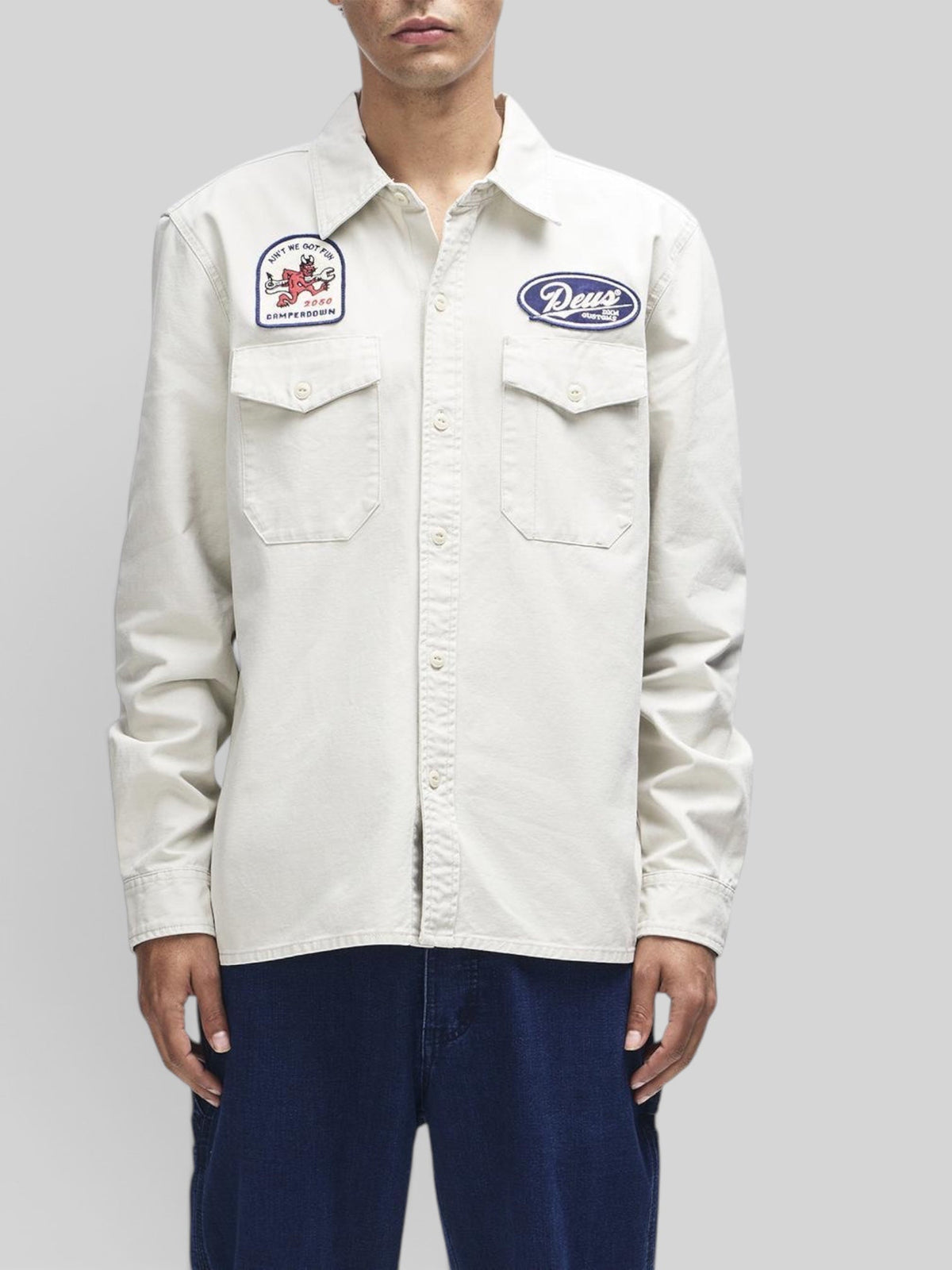 Baffle Haus Nomad shirt in dirty white cotton twill with embroidered patches and chest pockets on a male model