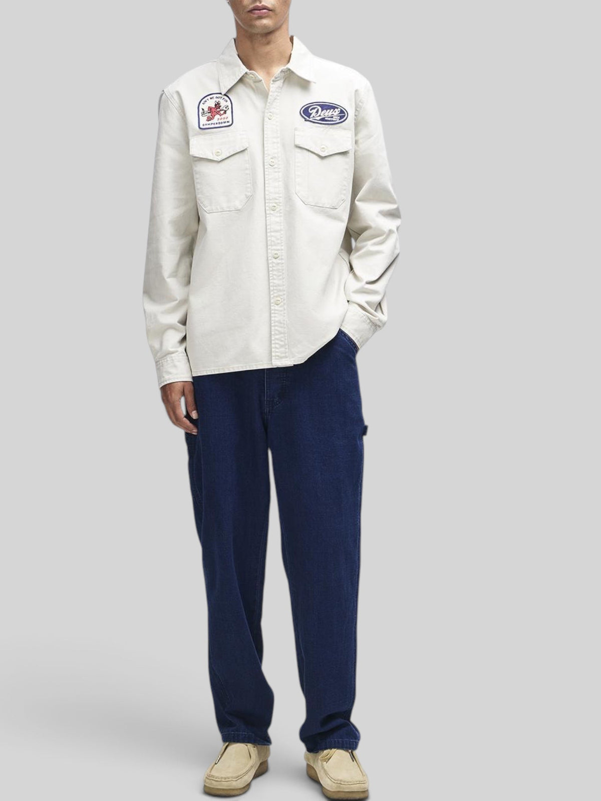 Baffle Haus Nomad shirt in dirty white cotton twill with embroidered patches, chest pockets, and button closure.