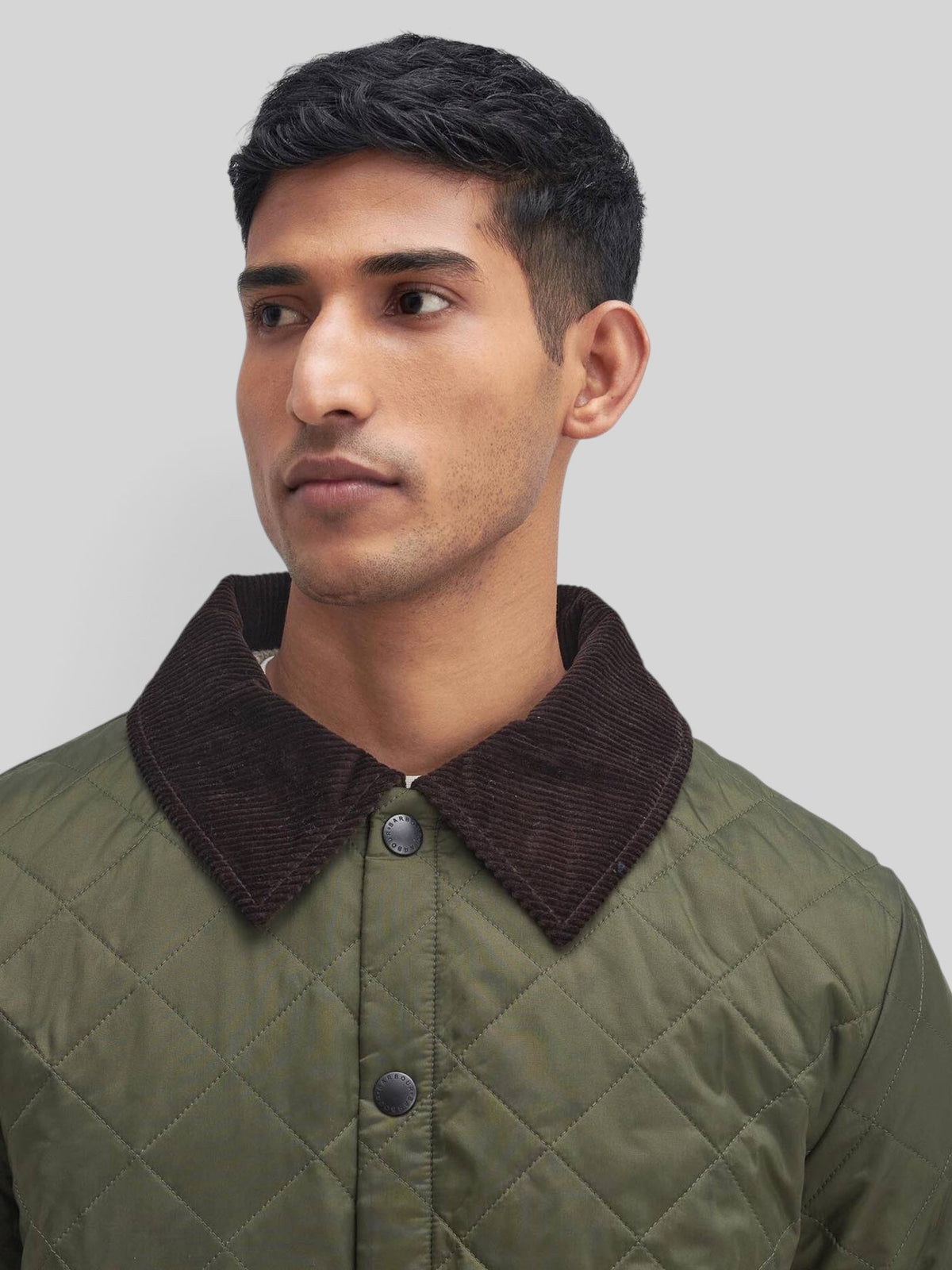 Baffle Haus Heritage Liddesdale olive green quilted jacket with a brown corduroy collar and snap-button front.