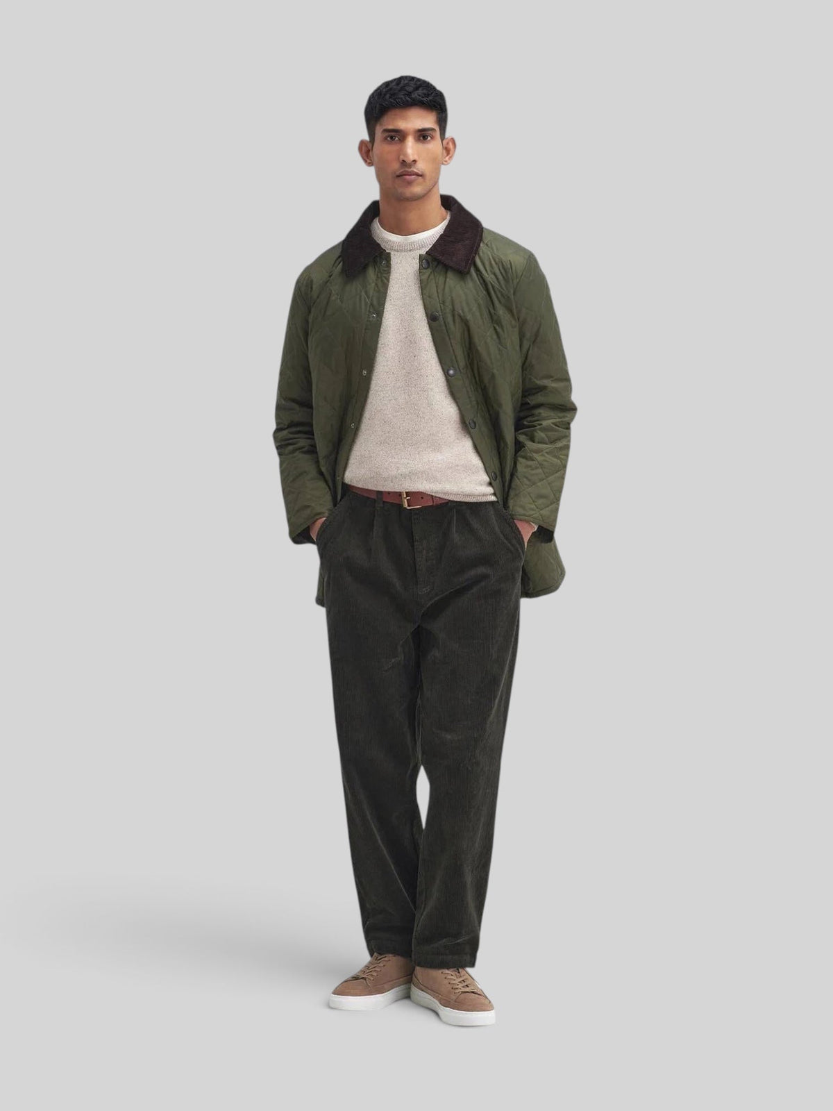 Baffle Haus Heritage Liddesdale olive quilted jacket with a corduroy collar worn by a man in a studio setting