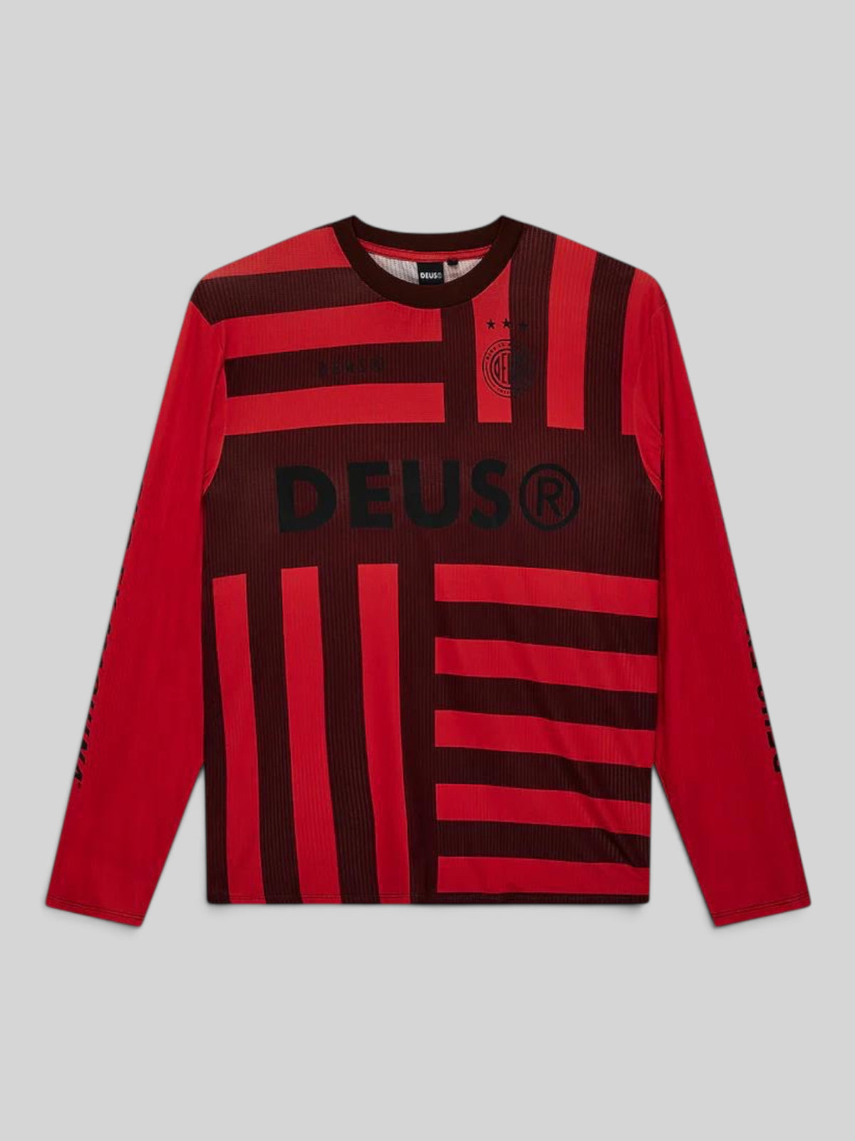 Baffle Haus Team Deus long-sleeve moto jersey in orange and black with bold striped graphics and logo detailing.