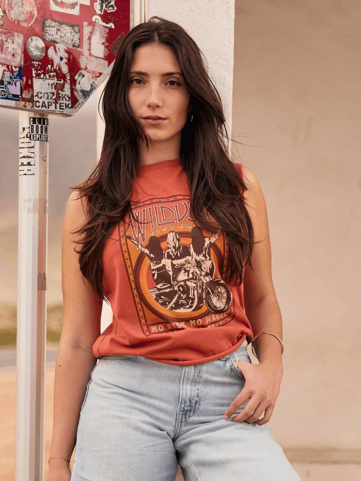 Baffle Haus orange oversized cotton tank top with vintage motorcycle graphic print and raw edge sleeves on a woman