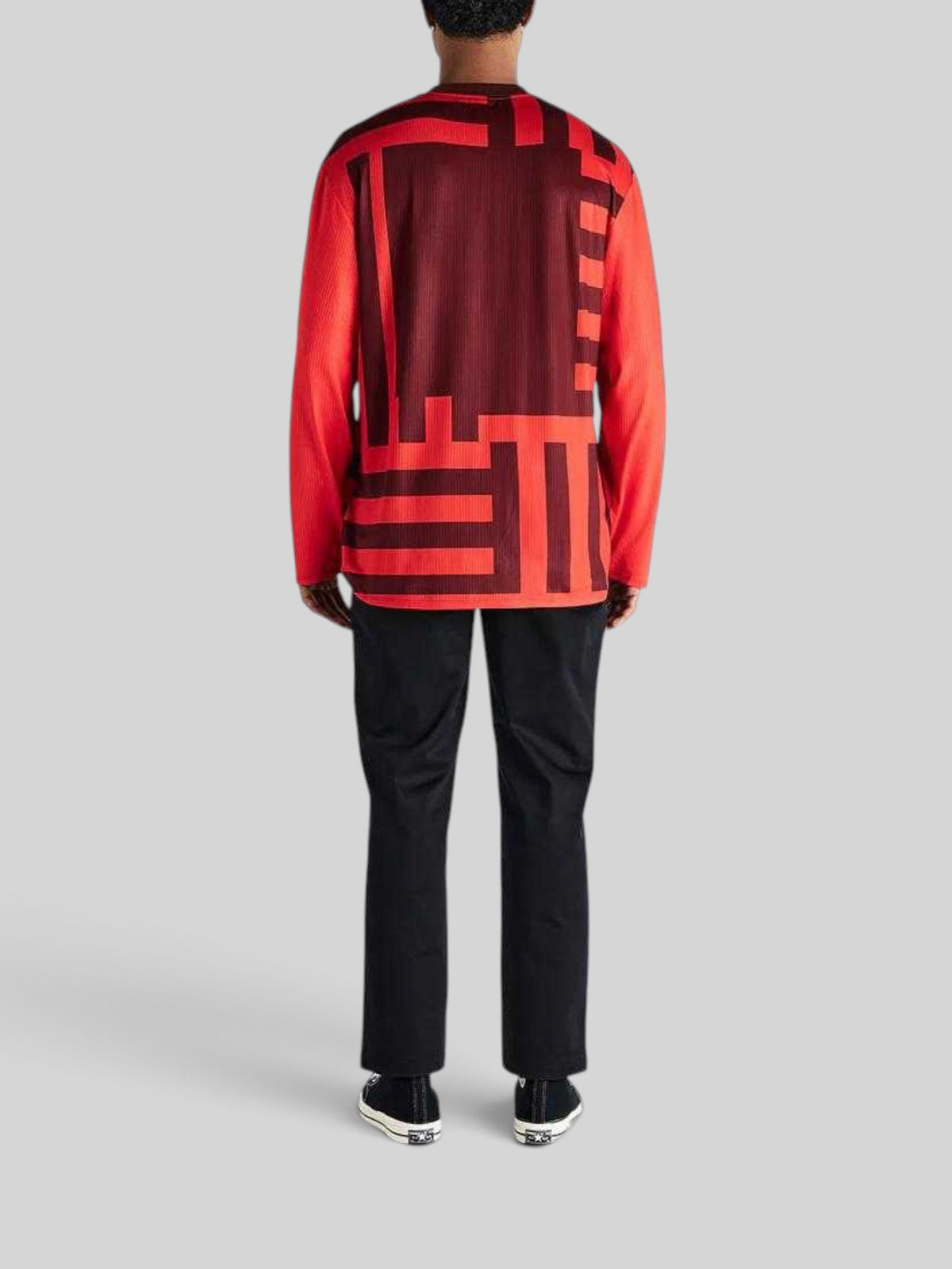 Baffle Haus Blackout Moto Jersey in orange and dark red with geometric graphic print, back view on a model.