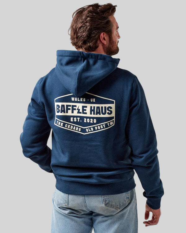 Back view of a man wearing a Baffle Haus pageant blue heavyweight cotton blend hoodie with a white logo graphic.