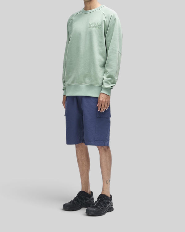 Baffle Haus Plenty Good Crew in loden frost green with chest print and nylon sleeve panels worn by a model