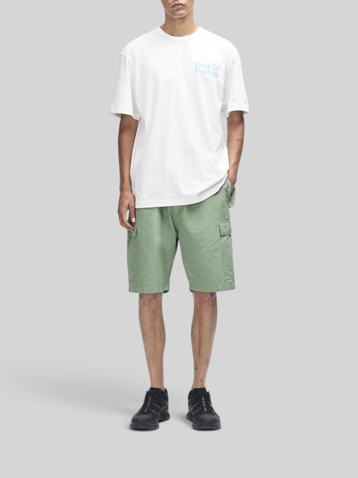 Baffle Haus Plenty Good Tee in vintage white with chest graphic, worn with sage green cargo shorts and black sneakers