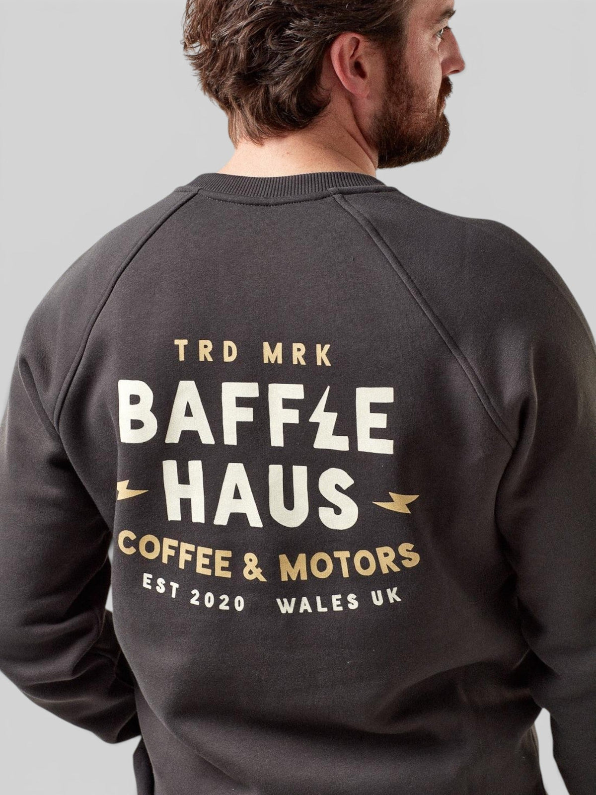 Baffle Haus Coffee & Motors sweatshirt in printers ink grey with back graphic print worn by a man