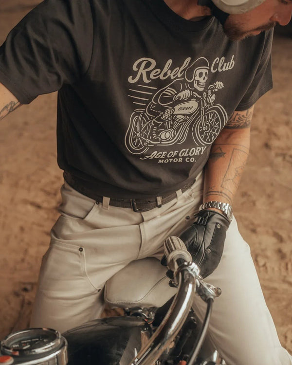 Baffle Haus Rebel Club black cotton t-shirt with vintage motorcycle graphic worn by a man on a bike