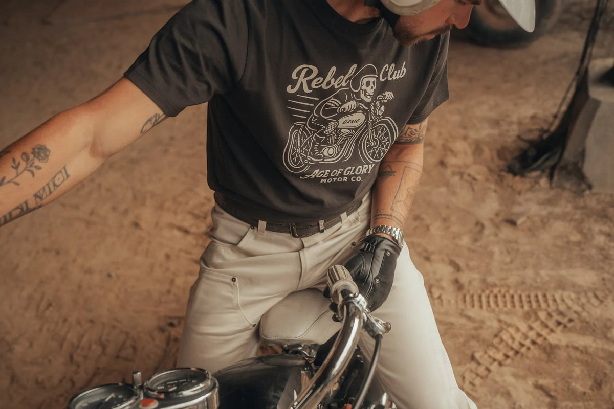 Baffle Haus Rebel Club black cotton t-shirt with vintage motorcycle graphic worn by a man on a bike