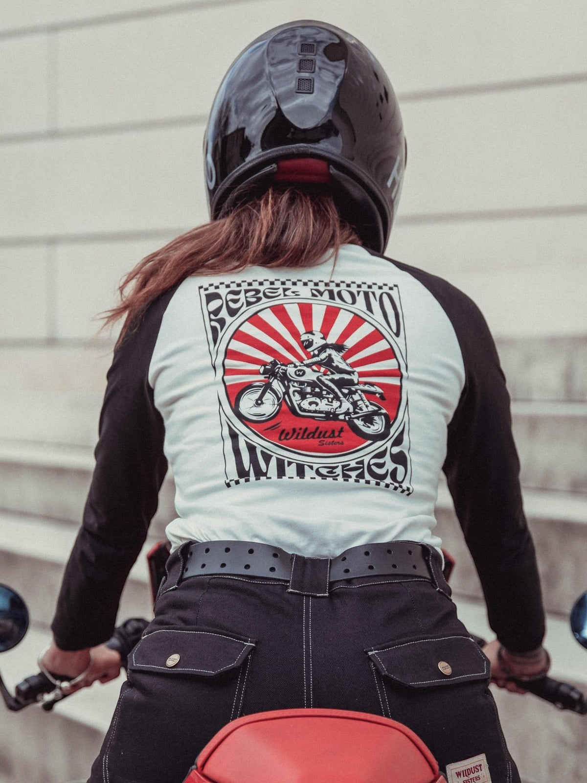 Baffle Haus Rebel long sleeve tee with graphic print of a motorcycle on the back, worn by a rider in a helmet.