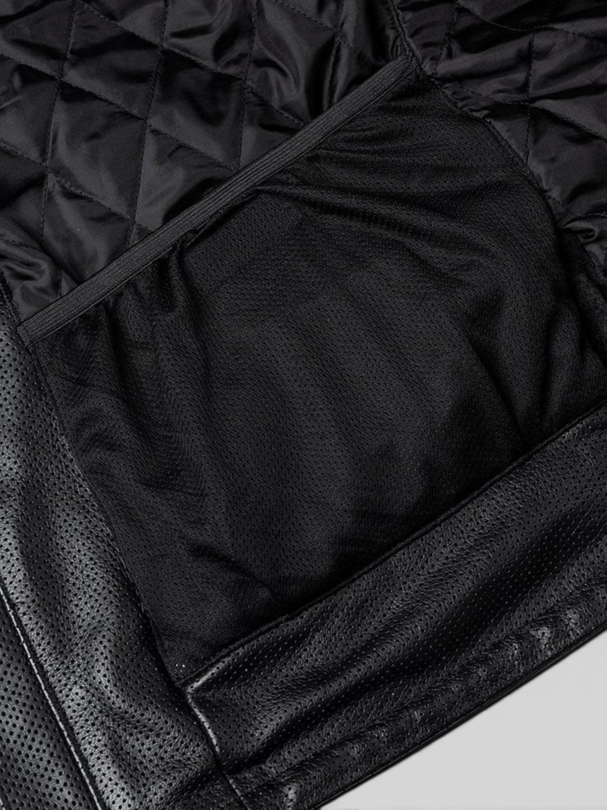 Interior view of Baffle Haus Motone Revolver leather jacket showing black diamond-quilted lining and mesh pocket