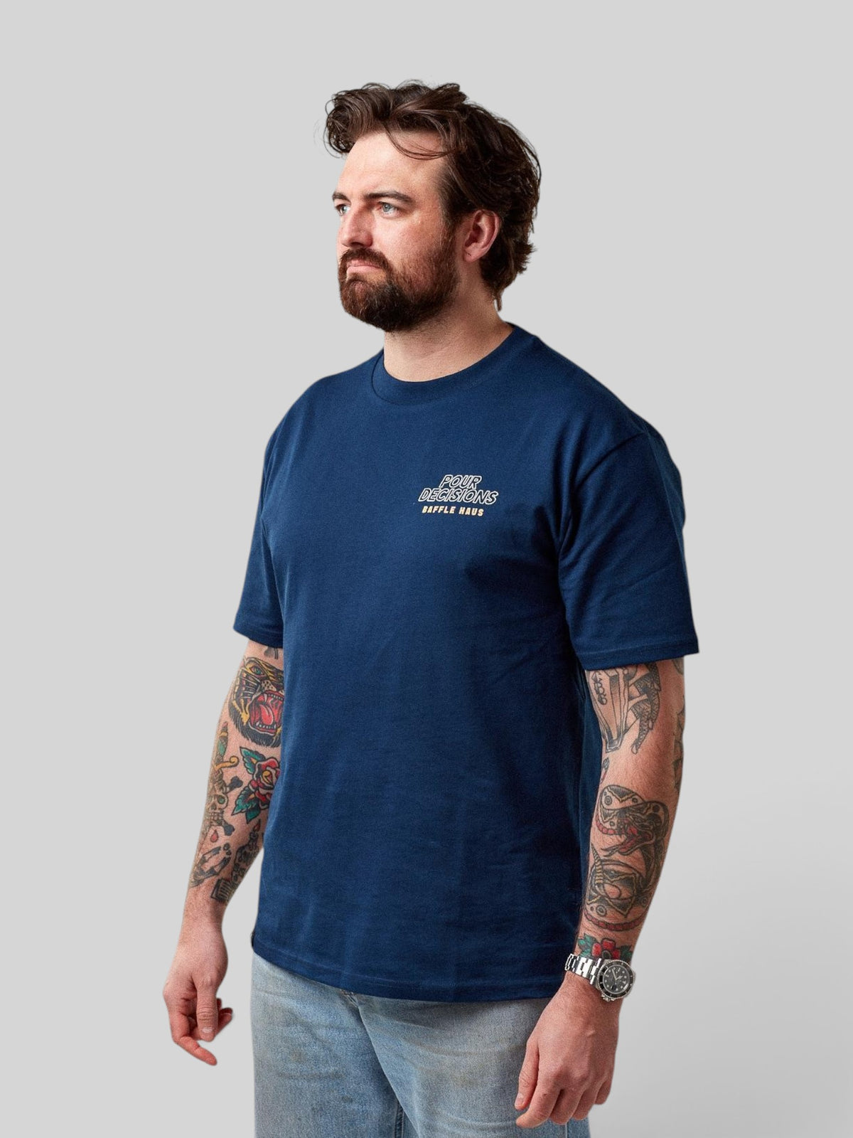 Baffle Haus Pour Decisions Coffee Club t-shirt in royal navy cotton worn by a bearded man with tattooed arms
