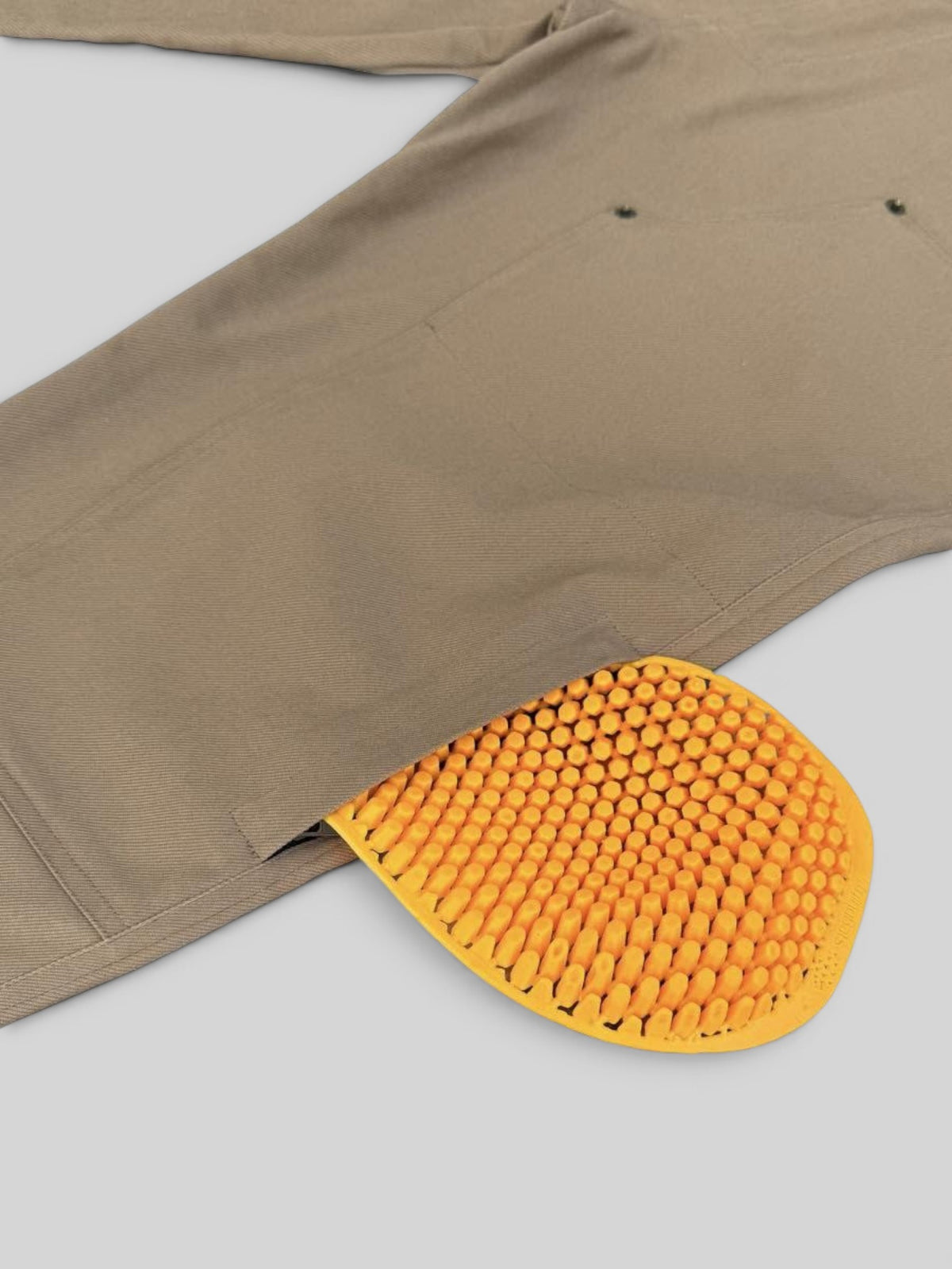 Baffle Haus Service Pants in desert khaki showing a removable yellow CE level 2 knee protector in a side pocket