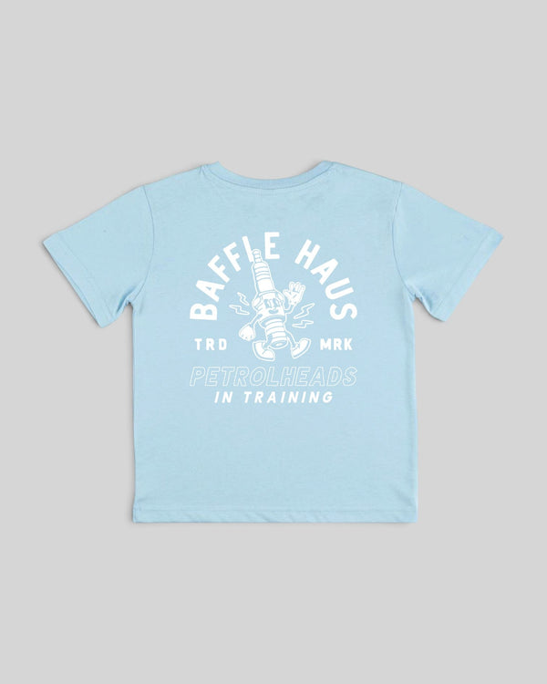 Back view of a sky blue Baffle Haus kids cotton t-shirt featuring a white graphic of Sparky the animated spark plug.
