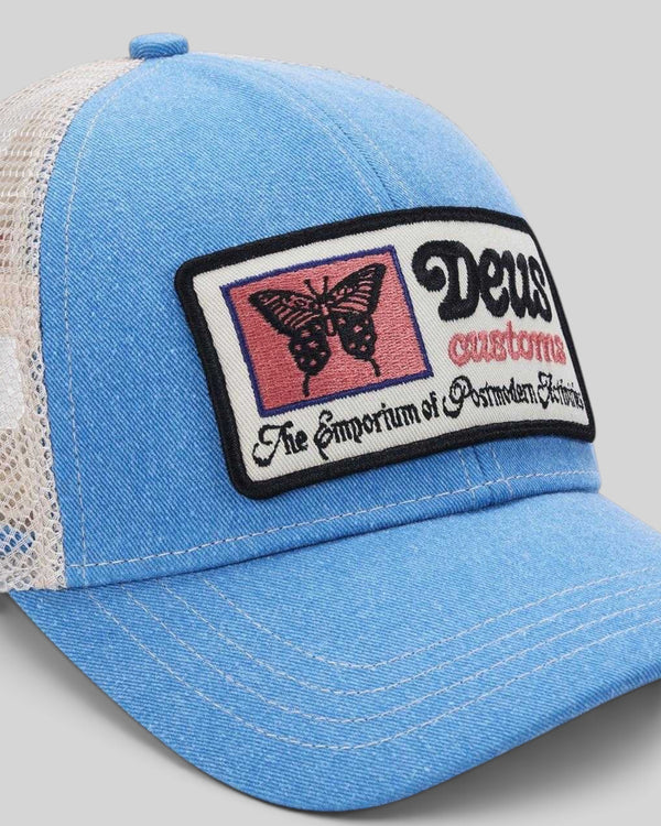 Baffle Haus Slapstick Trucker hat in Bonnie Blue nylon with a rectangular graphic patch featuring a butterfly