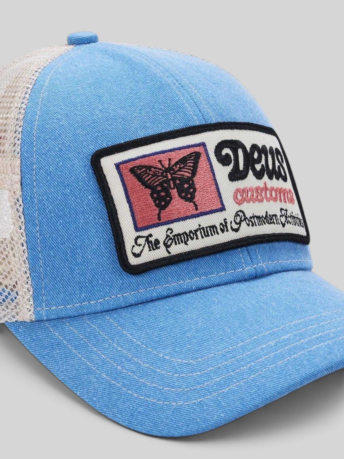 Baffle Haus Slapstick Trucker hat in Bonnie Blue nylon with a rectangular graphic patch featuring a butterfly