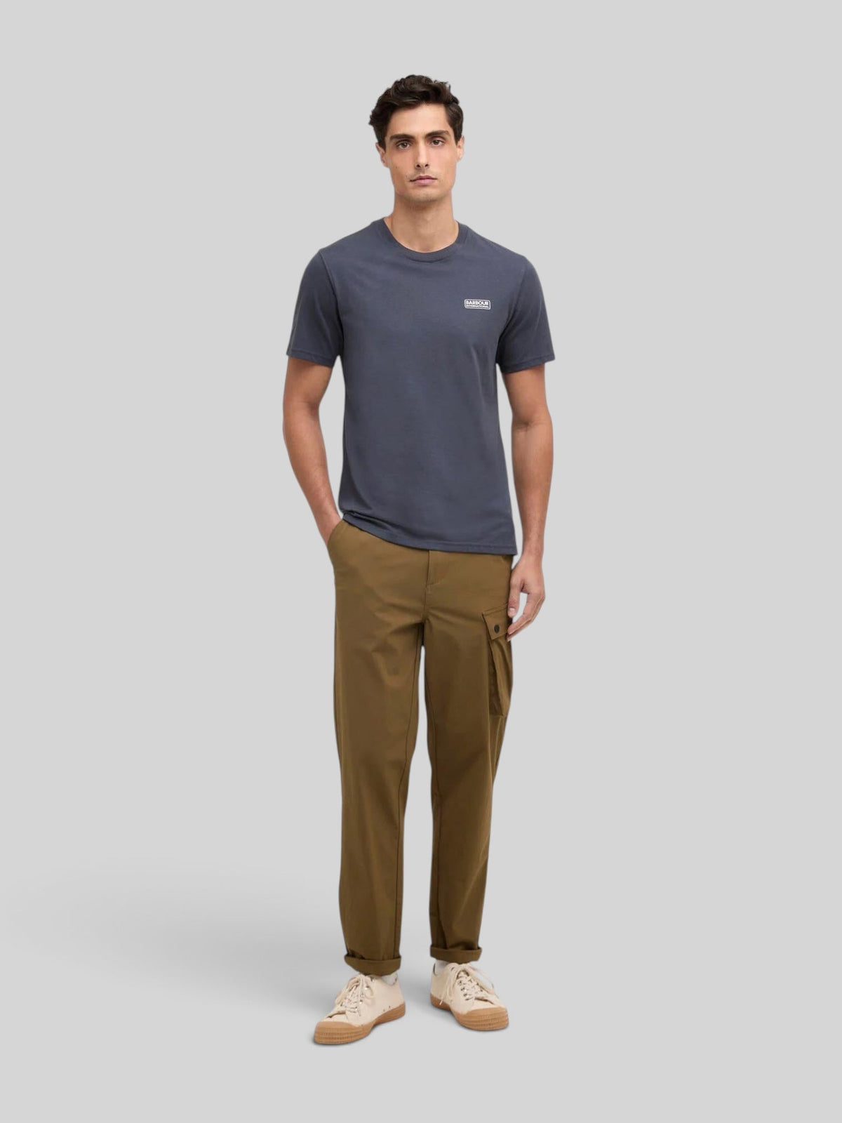 Baffle Haus storm grey cotton crew neck t-shirt with small chest logo worn by a male model with brown cargo pants