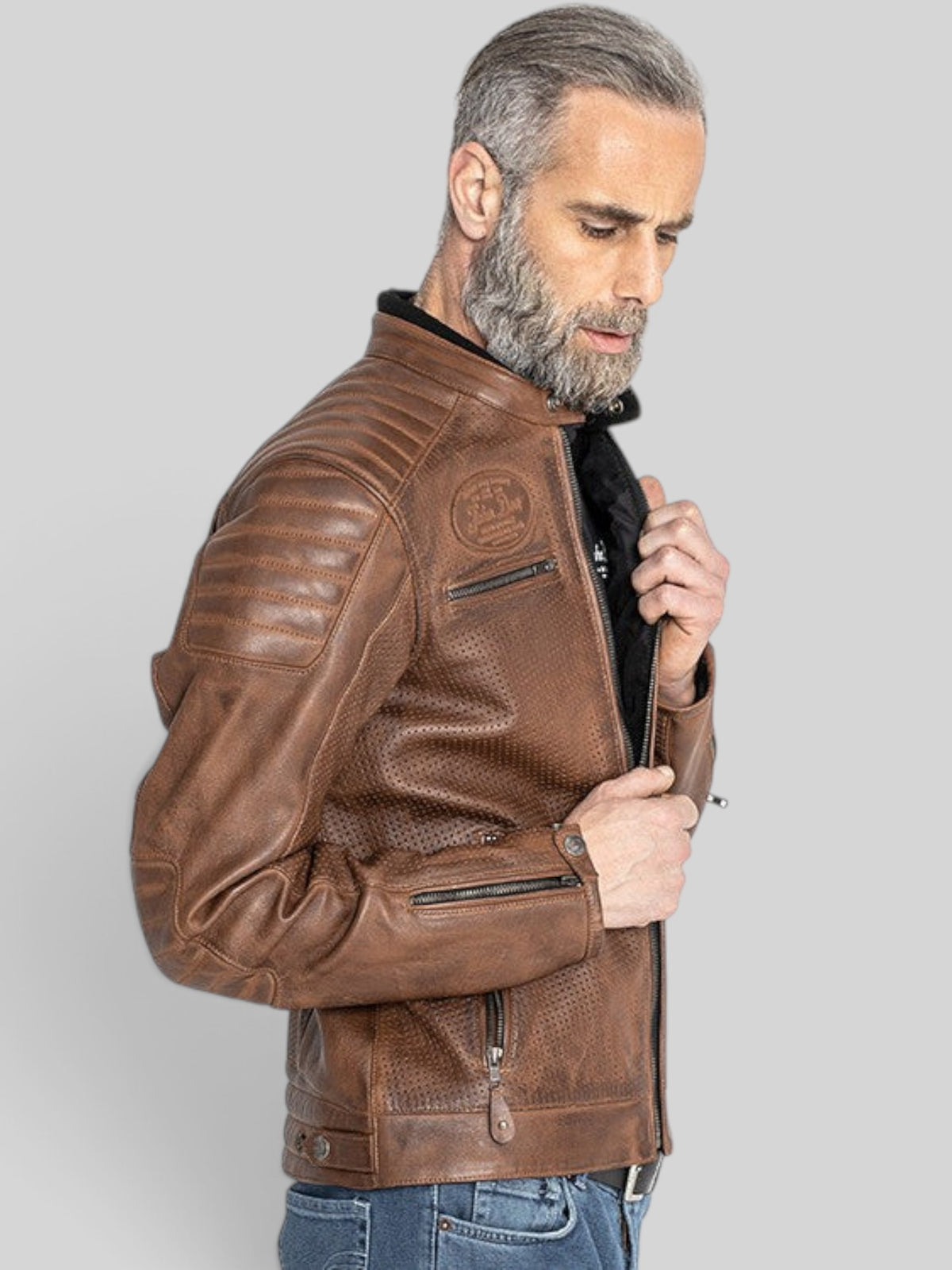 Baffle Haus Storm tobacco perforated leather motorcycle jacket with padded shoulders and YKK zippers on a model.