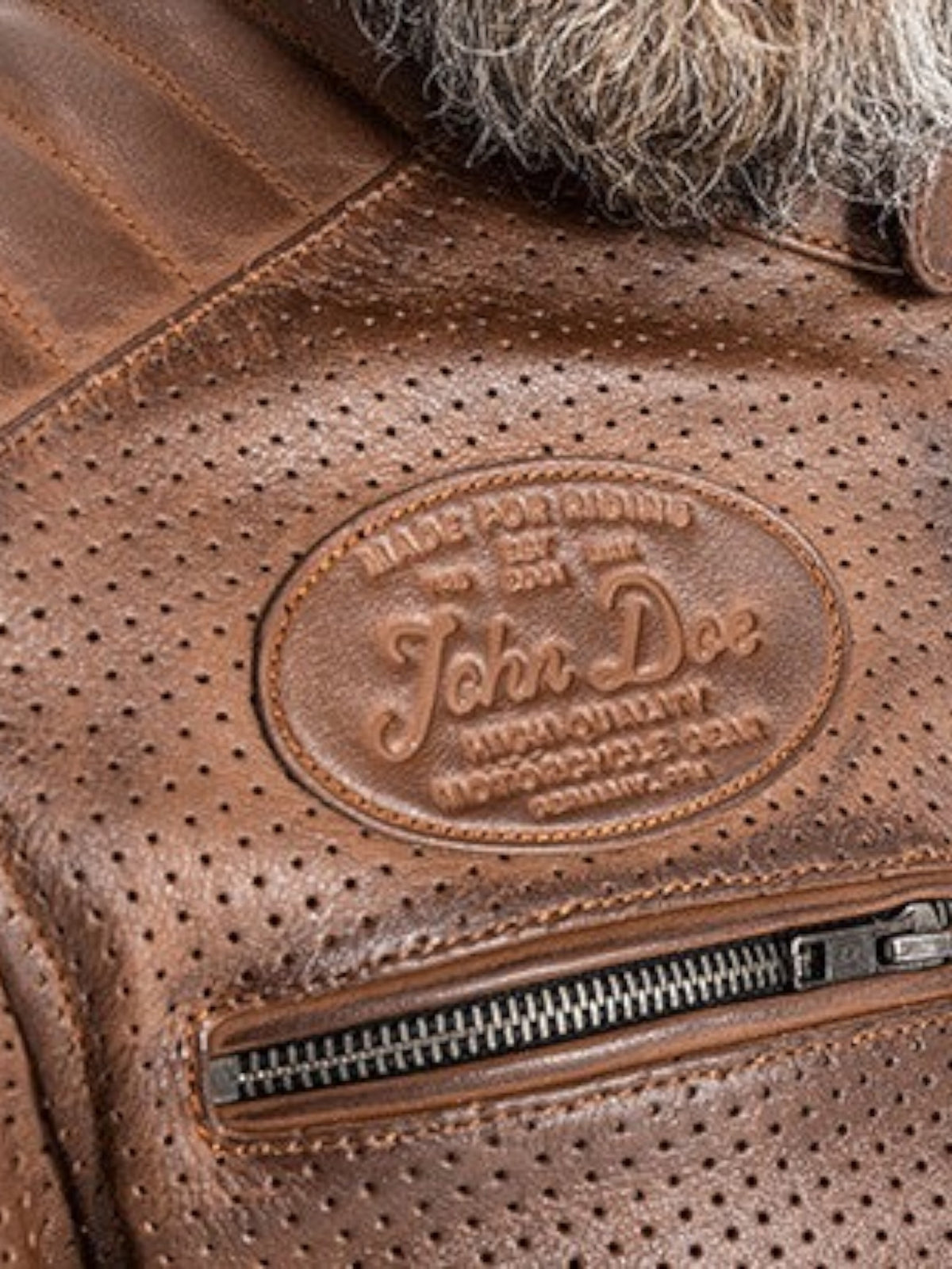 Baffle Haus Storm tobacco perforated leather motorcycle jacket with embossed John Doe logo and zippered chest pocket