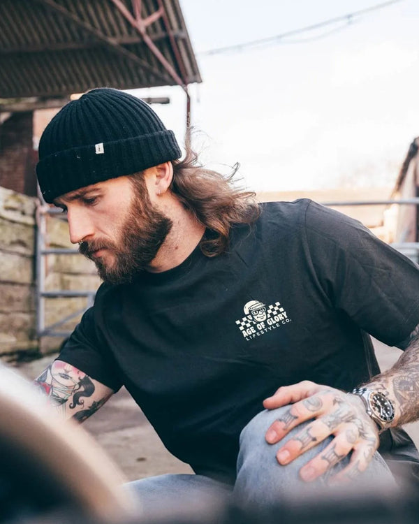 Baffle Haus Sunday Service black cotton t-shirt with screen printed chest logo worn by a man in a beanie