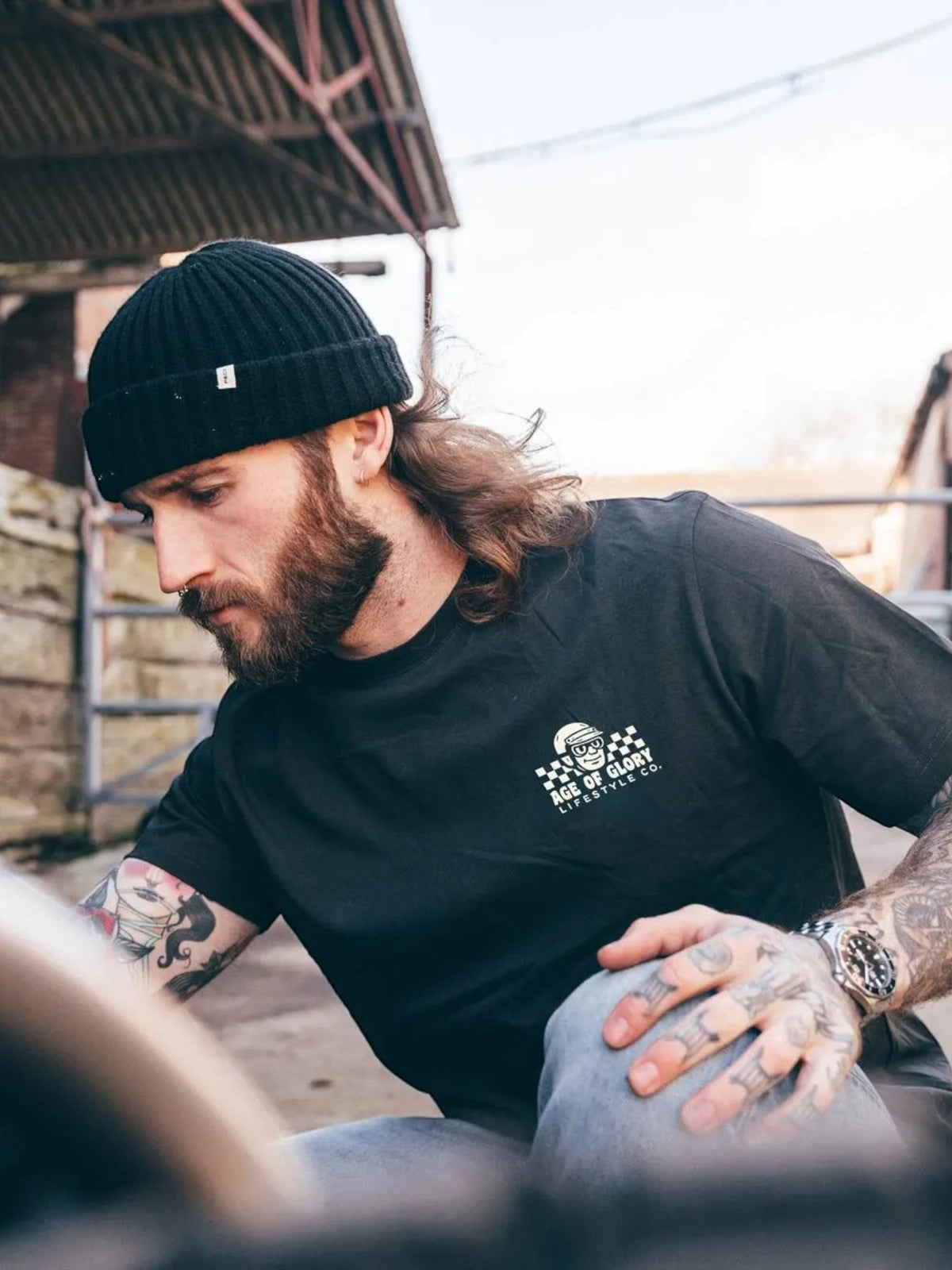 Baffle Haus Sunday Service black cotton t-shirt with screen printed chest logo worn by a man in a beanie