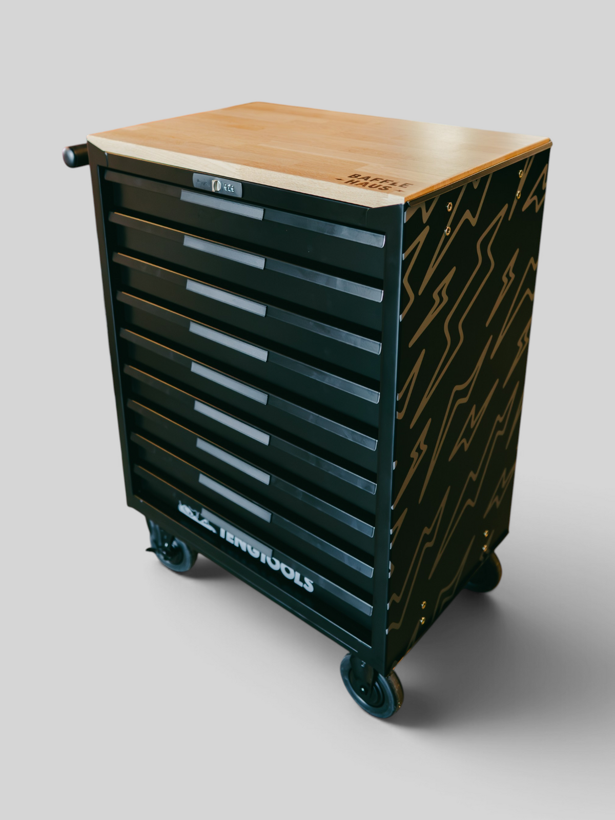 Baffle Haus Teng x Baffle Haus black metal tool box with a wooden top and lightning bolt pattern in a garage setting