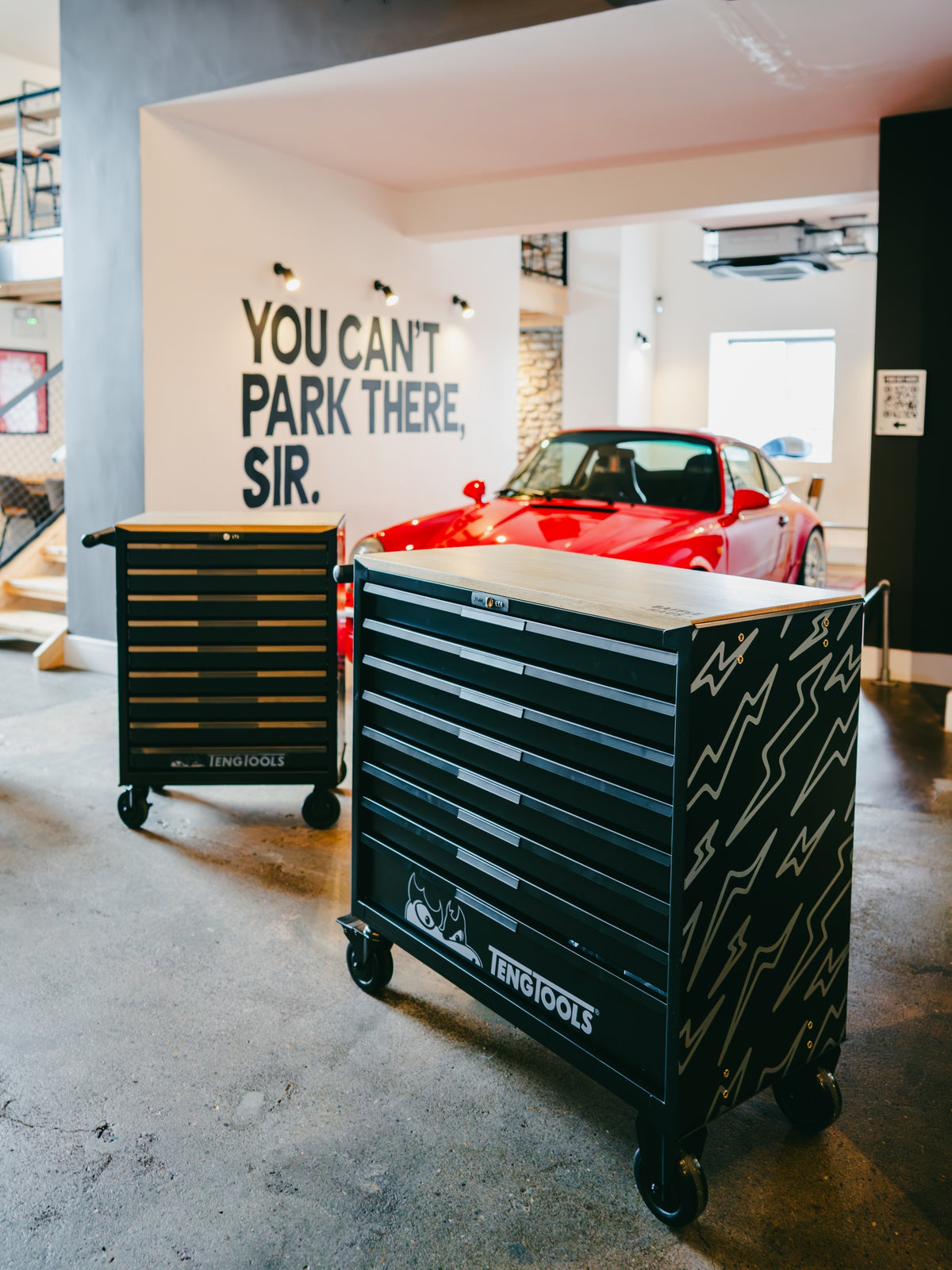 Baffle Haus Teng Tools black metal rolling tool cabinet with white lightning bolt graphics in a garage setting