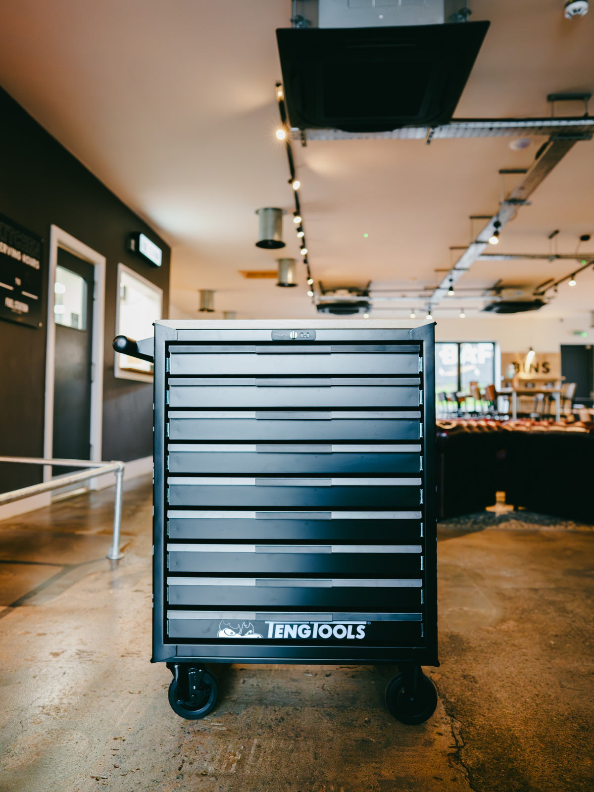 Baffle Haus Teng Tools black metal rolling tool cabinet with eight drawers in a workshop setting