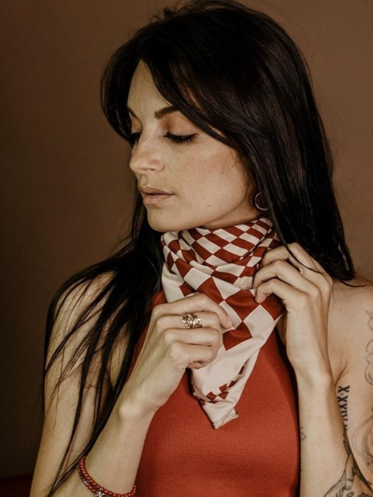 Baffle Haus Petrol Junkies scarf in terracotta and cream checkerboard print worn by a woman