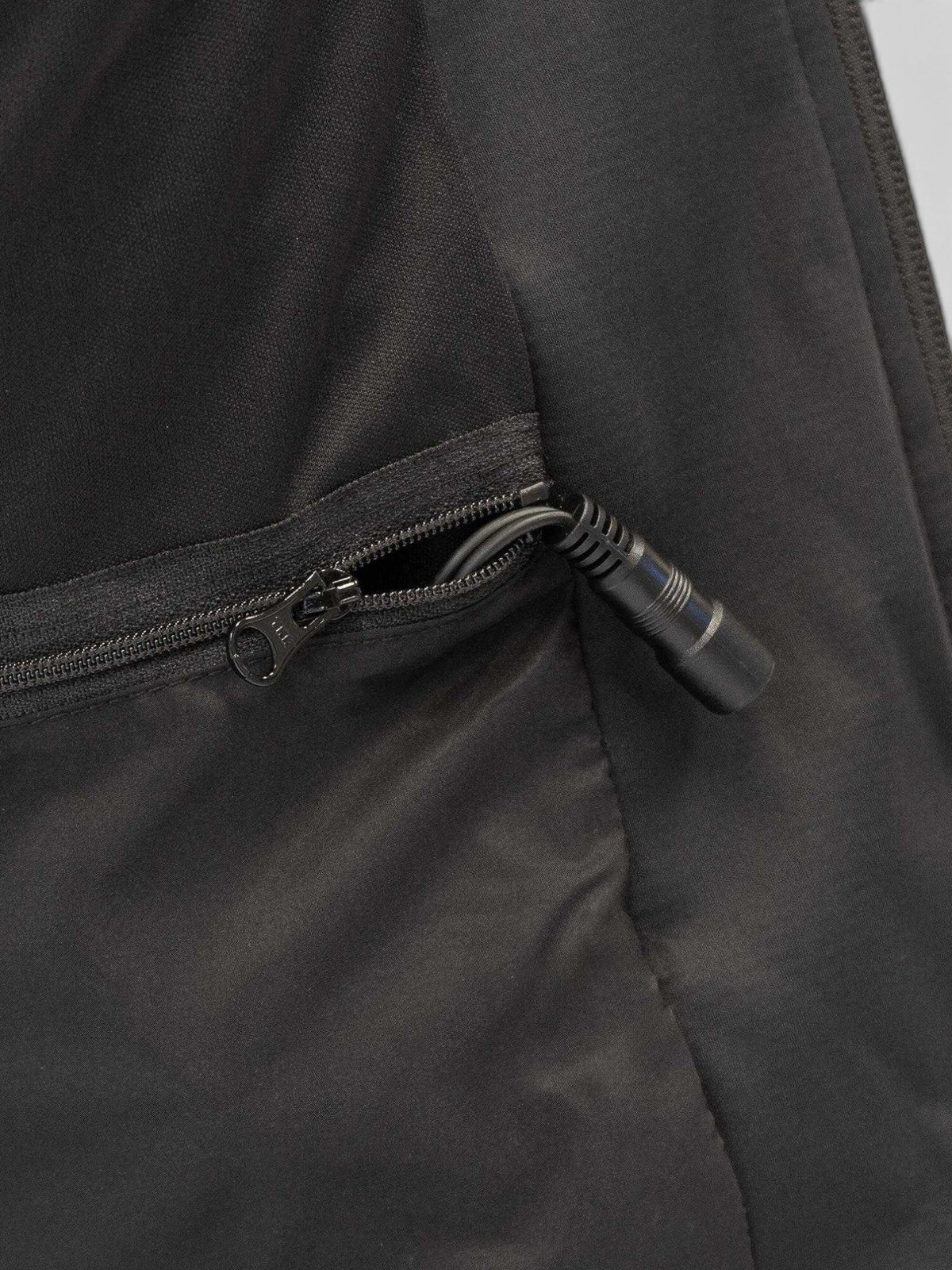 Baffle Haus Thermavolt heated jacket showing the internal power connection cable inside a zipped storage pocket.
