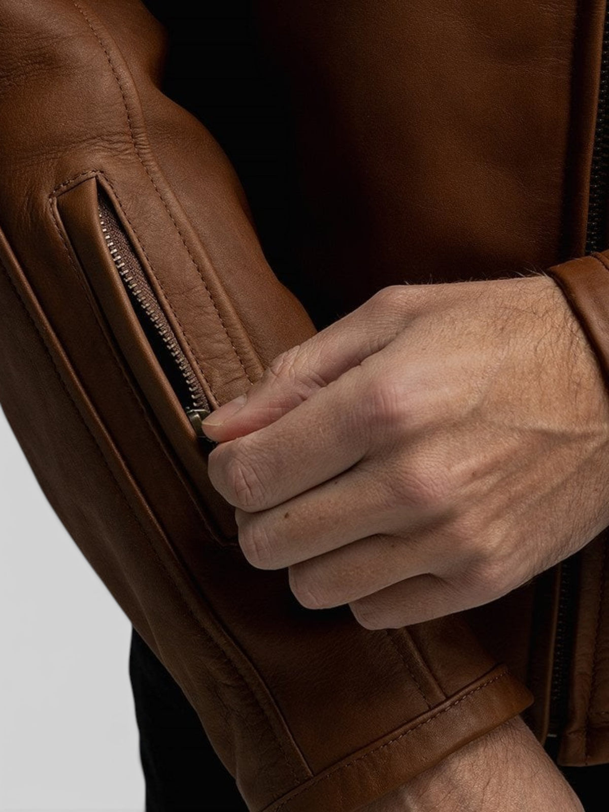 Baffle Haus Motone Revolver tobacco leather motorcycle jacket featuring a zippered forearm stash pocket
