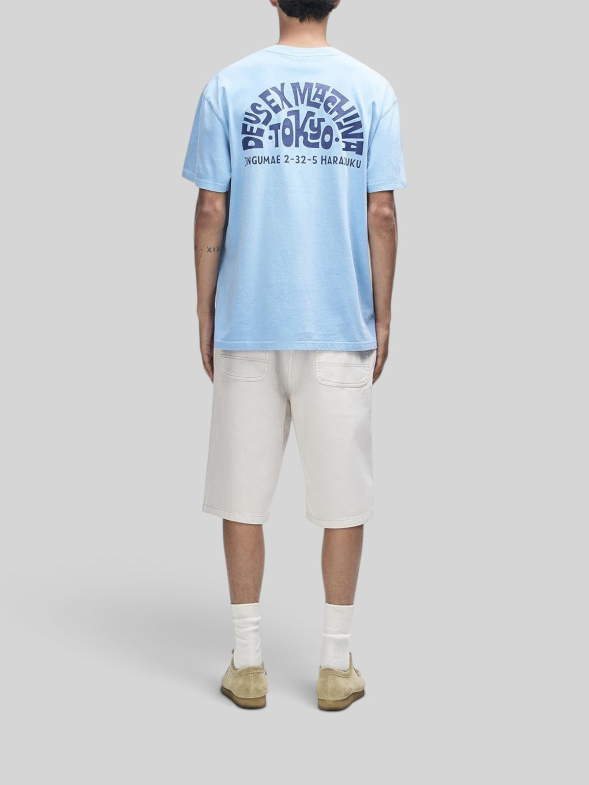 Baffle Haus Tokyo Address Tee in bonnie blue recycled cotton with back graphic print, worn with cream shorts