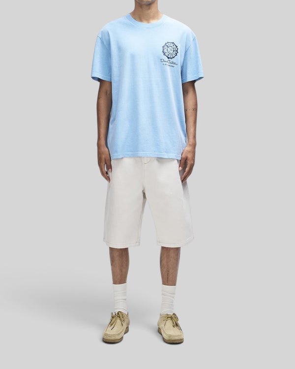 Baffle Haus Tokyo Address Tee in bonnie blue recycled cotton with chest graphic, worn with off-white shorts.
