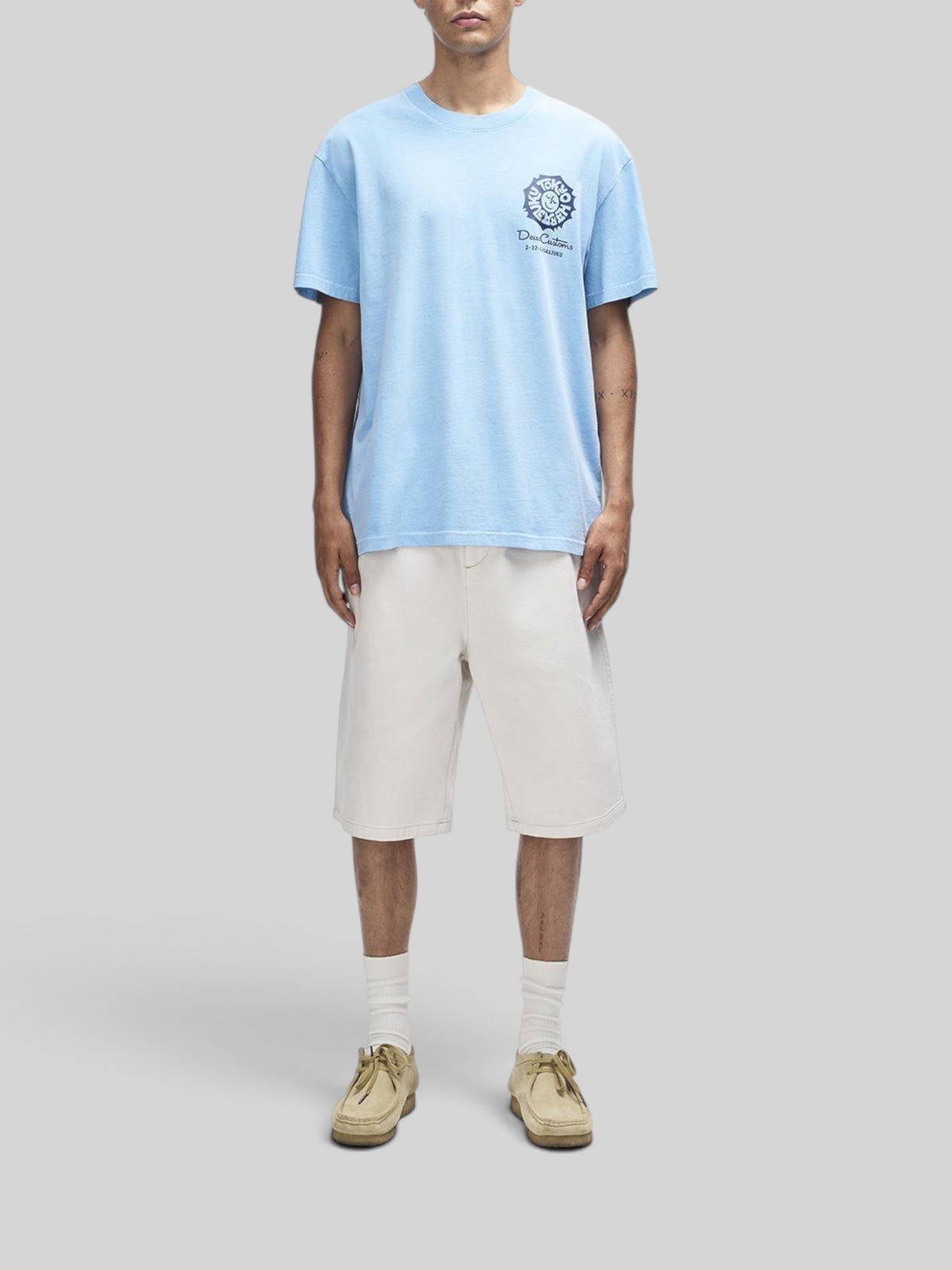 Baffle Haus Tokyo Address Tee in bonnie blue recycled cotton with chest graphic, worn with off-white shorts.