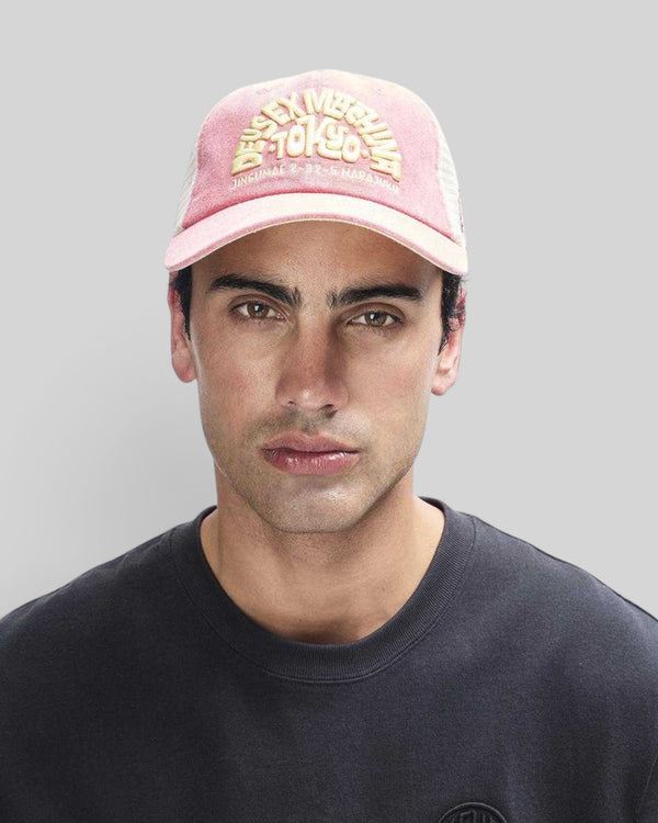 Baffle Haus Tokyo Address trucker hat in melon red with yellow embroidery, contrast stitching, and mesh back.