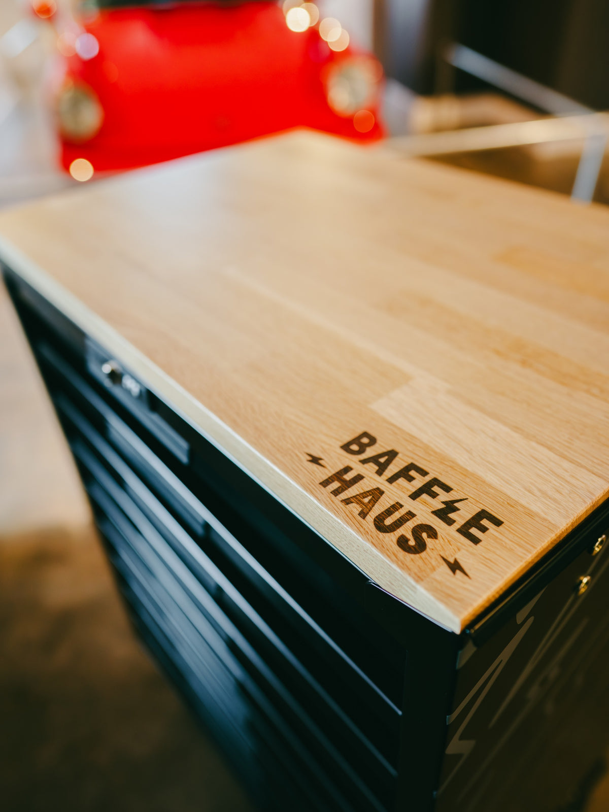 Baffle Haus tool box featuring a light wood top with branded logo and black metal drawers in a garage setting