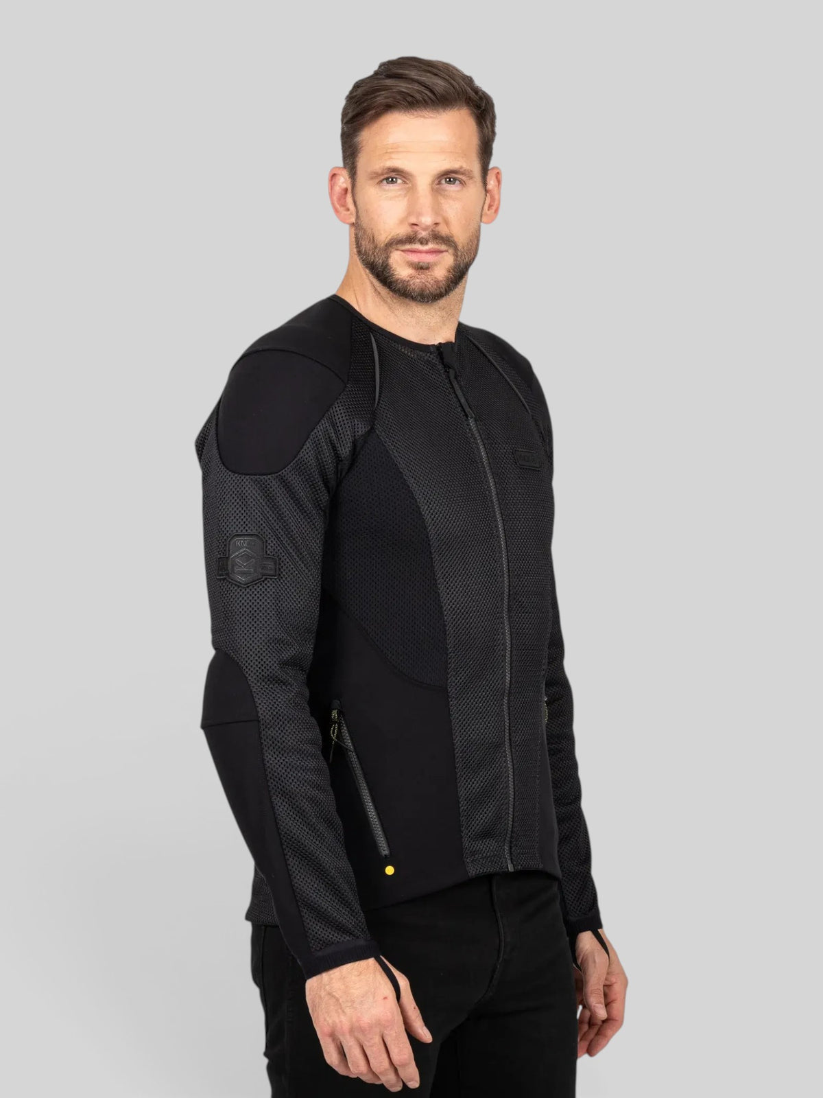 Baffle Haus Urbane Pro MK3 black motorcycle protective jacket worn by a man, featuring mesh panels and zip pockets.