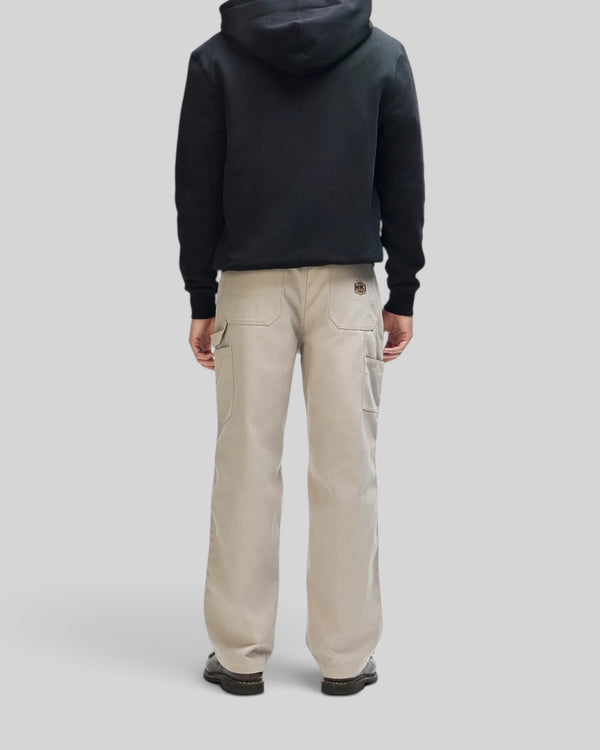 Baffle Haus Victory Lap black zip hoodie worn with beige utility pants, back view showing boxy fit and hood