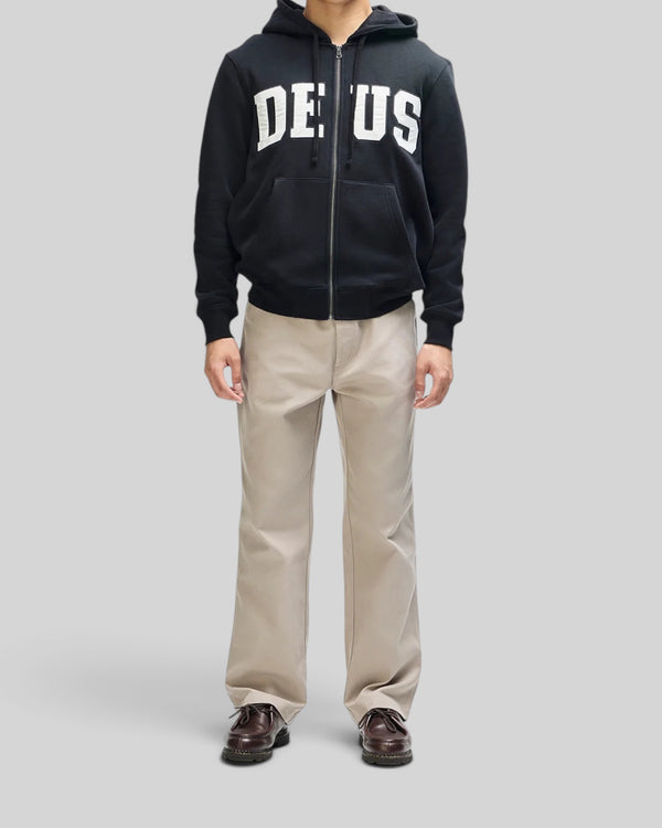 Baffle Haus Victory Lap black zip hoodie with white chest applique, kangaroo pocket, and drawstring hood on a model