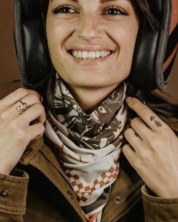 Baffle Haus Wildust vintage racer scarf in ecru with racing stripes worn by a woman under a motorcycle helmet