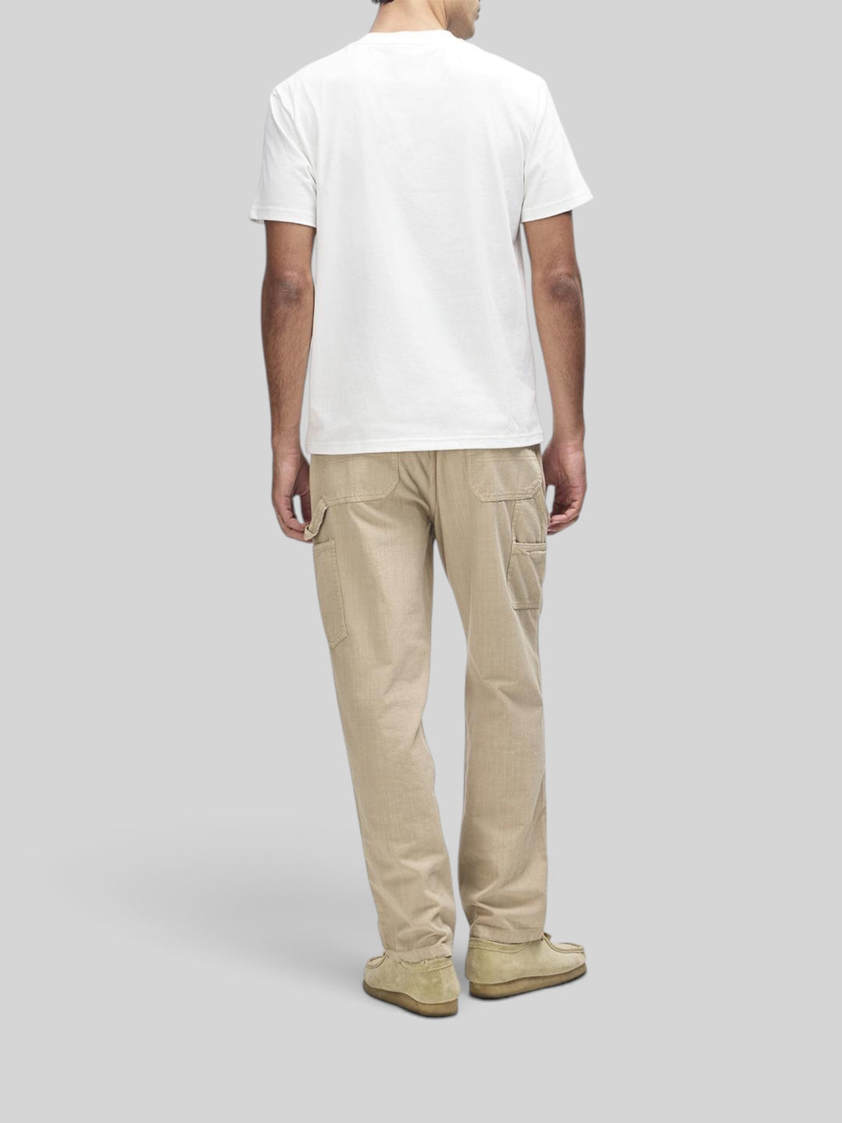 Baffle Haus vintage white box fit short sleeve t-shirt worn with beige trousers from behind