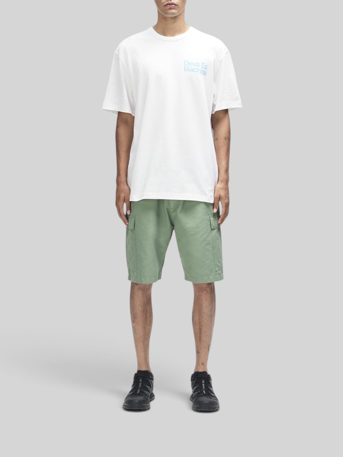 Baffle Haus Plenty Good Tee in vintage white with chest print, worn with green cargo shorts and black sneakers.