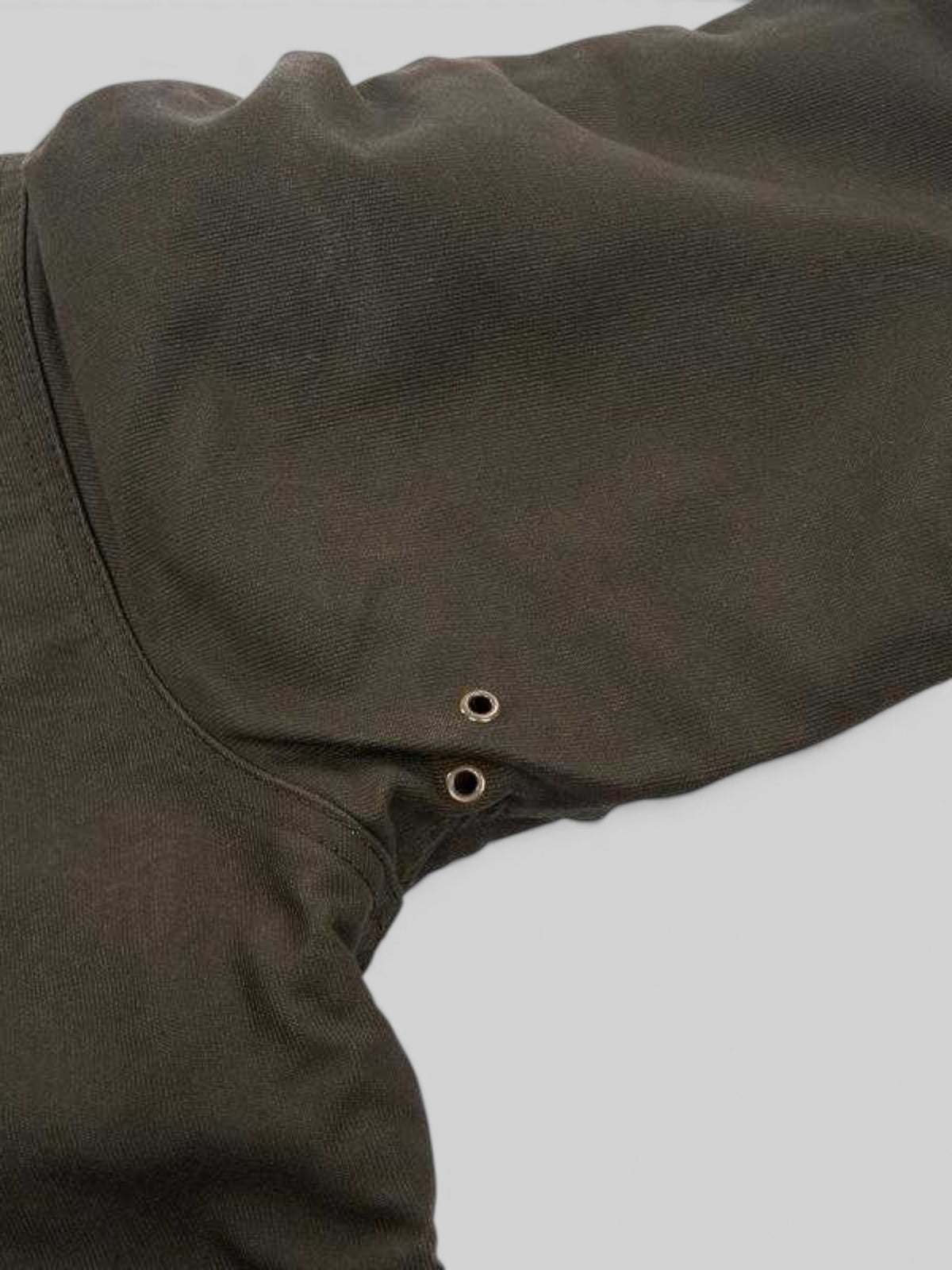 Baffle Haus waxed olive N1 deck jacket showing underarm ventilation eyelets on the durable jungle cloth fabric