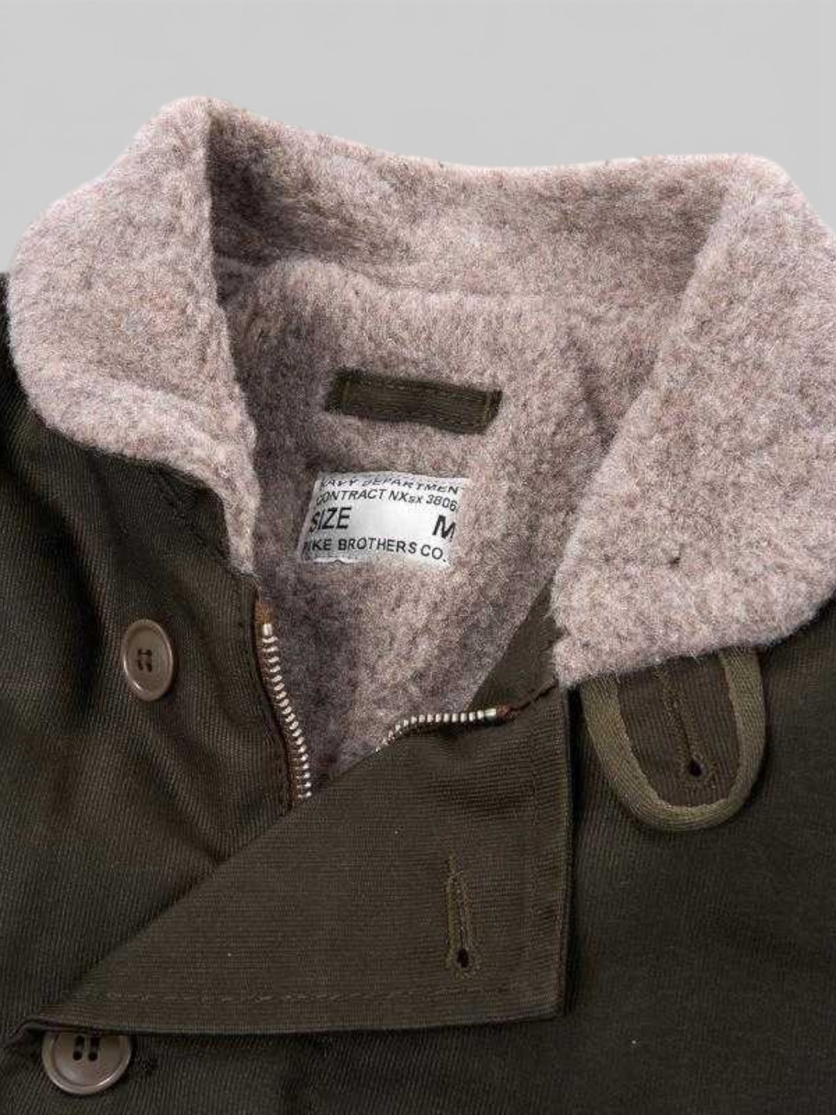 Baffle Haus 1944 N1 Deck Jacket in waxed olive cotton with a warm wool lining and vintage style collar detail