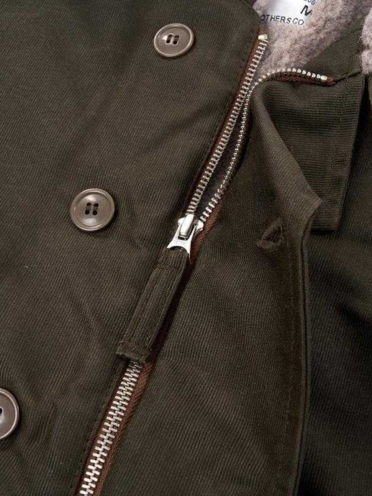 Baffle Haus waxed olive N1 deck jacket featuring a vintage Talon zipper, wool lining, and durable jungle cloth fabric.