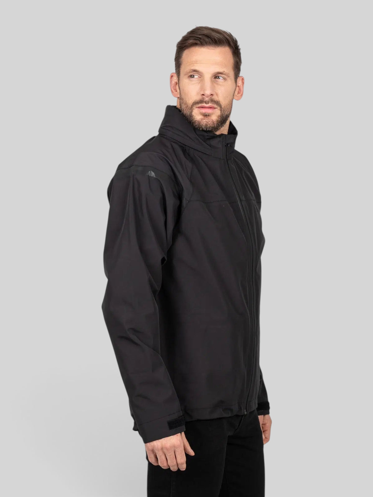 Baffle Haus Welbeck MK2 waterproof black motorcycle overjacket with high collar and adjustable cuffs on a male model