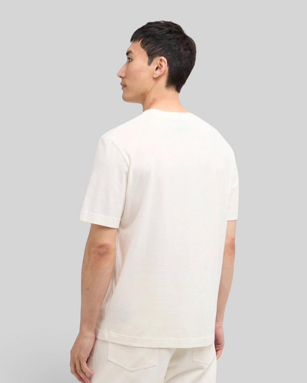 Back view of a man wearing a Baffle Haus whisper white cotton t-shirt with a relaxed fit and open cuffs.