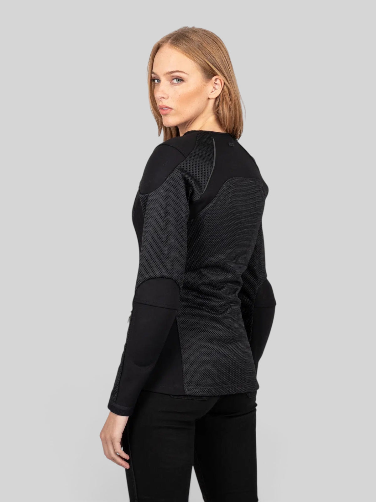 Baffle Haus Womens Urbane Pro MK3 black motorcycle armoured jacket worn by a model, back view showing mesh panels.