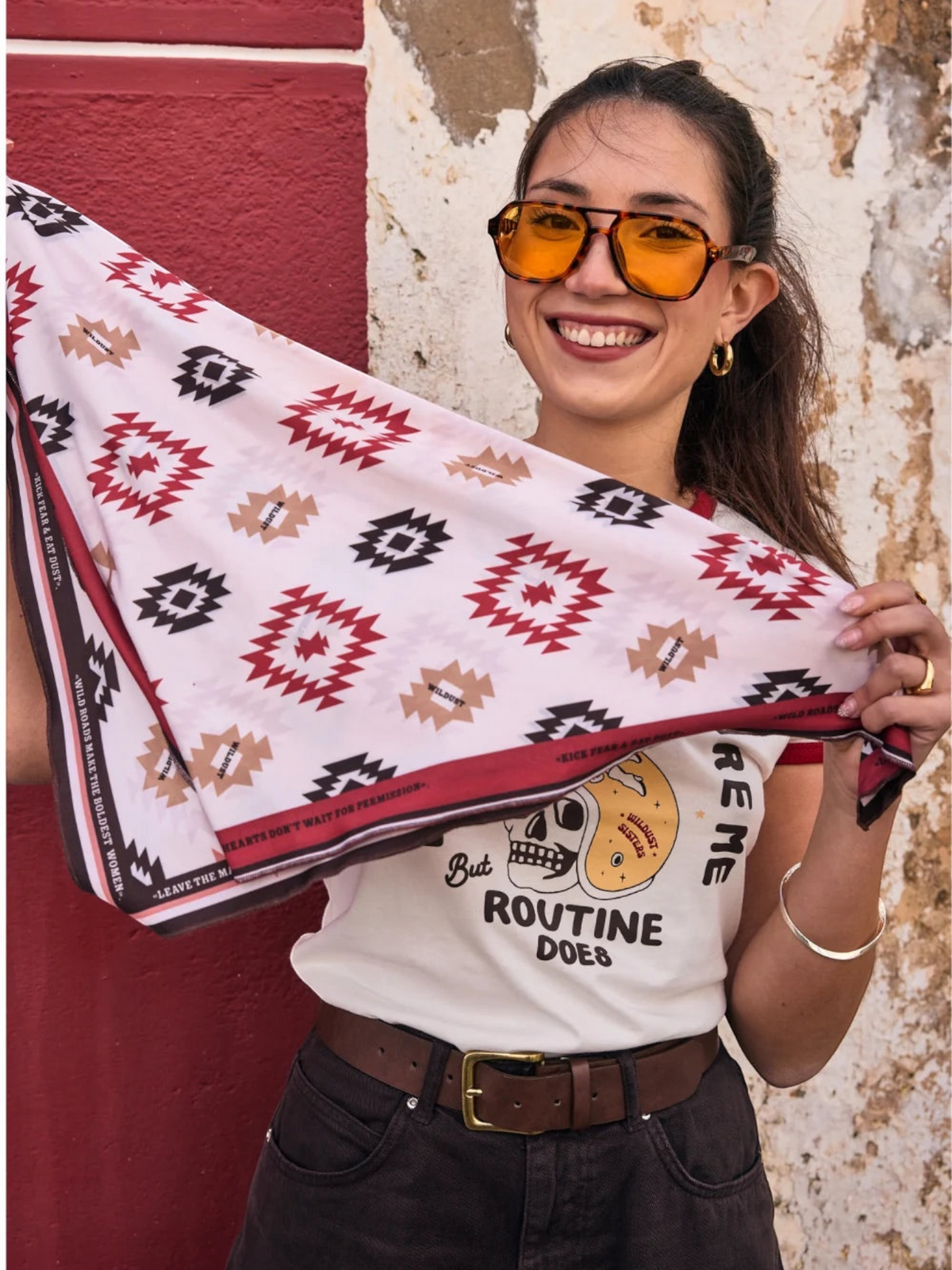 Baffle Haus Apache motorcycle scarf with geometric western pattern in beige, terracotta, and brown worn by a woman